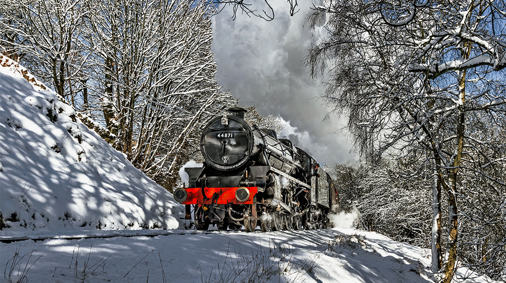 Steam engine travelling through a snowy landscape